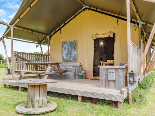 una tienda con un banco y una mesa en ella en Muntjac - Uk47396, en Bawdeswell