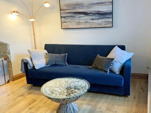a blue couch in a living room with a table at Fisherman's Cottage in Plymouth