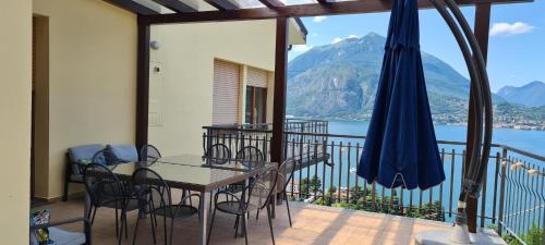 a balcony with a table and chairs and an umbrella at Villa gli Ulivi - Bariloche Lake & Mountain View in Perledo