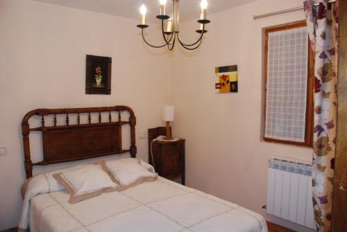 1 dormitorio con cama y lámpara de araña en Casa Rural Janet, en Izalzu