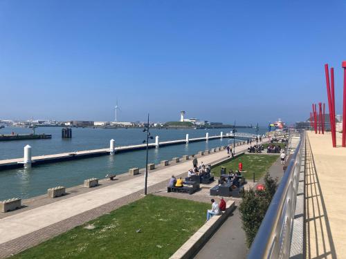 Un groupe de personnes assises sur des bancs près de l'eau dans l'établissement Au quai 34, à Boulogne-sur-Mer