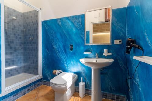 a blue bathroom with a toilet and a sink at "L'Oasi di Favignana" Room and Charme in Favignana