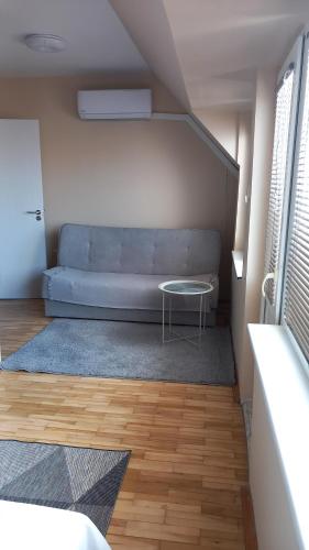 a living room with a couch and a table at Апартамент Плажен рай in Burgas City