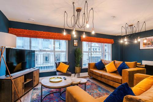 a living room with a couch and a tv at The Definition Apartment in the Northern Quarter by Rest&Recharge in Manchester