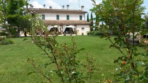 a house in a field with a grass yard at Locanda Antico Casale Cesenatico in Cesenatico