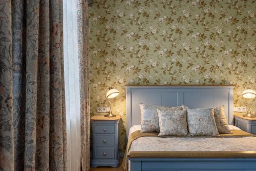 a bedroom with a bed and two night stands at Roze Boutique Apartments in Liepāja