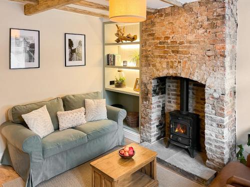 a living room with a couch and a fireplace at Cosy Cottage in Howden