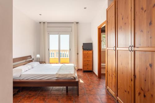 a bedroom with a bed and a dresser and a window at Villa Roselles in Lloret de Mar