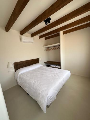 a bedroom with a white bed and a wooden ceiling at Casa Bel - Apartment 6 in Miami Platja