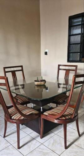 a dining room table with two chairs and a glass top at Casa do Centro Piri in Pirenópolis