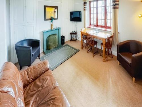 a living room with a couch and a fireplace at Latrigg View - Uk45177 in Threlkeld