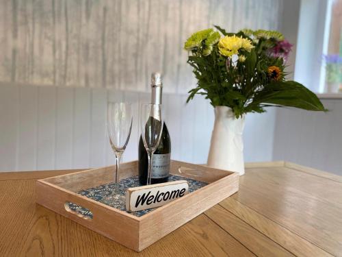 a bottle of wine and a glass and a vase with flowers at The Old Toll House in Coalport