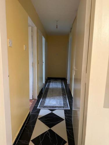 a hallway with a black and white tile floor at Thalia apartment in Nairobi