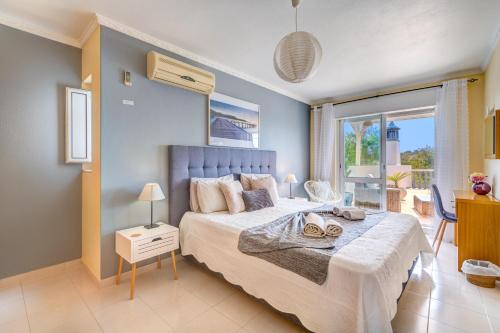 a bedroom with a large bed and a balcony at Vila da Encosta - Private - Heated swimming pool - By bedzy in Albufeira