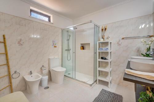 a bathroom with a shower and a toilet and a sink at Vila da Encosta - Private - Heated swimming pool - By bedzy in Albufeira
