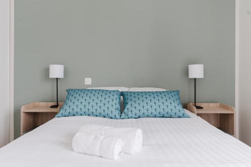 キブロンにあるZenitude Hôtel Résidences Quiberonのベッドとタオル2枚のある寝室