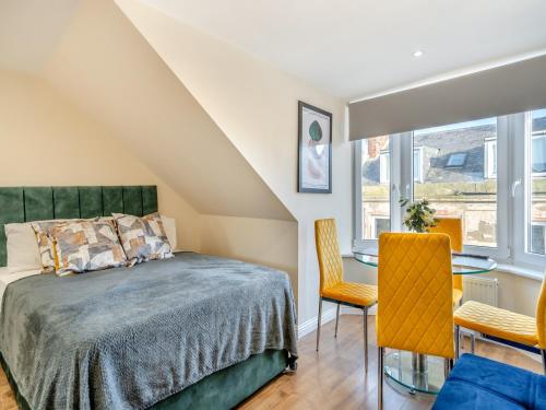 a bedroom with a bed and a table and chairs at Apartment Six - Uk44288 in Arbroath