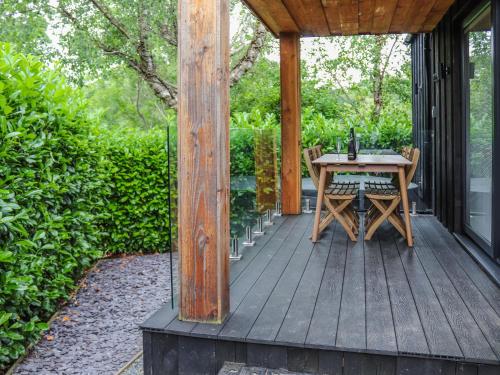 a wooden deck with a table on a house at Menai Lodge - Uk47604 in Caernarfon