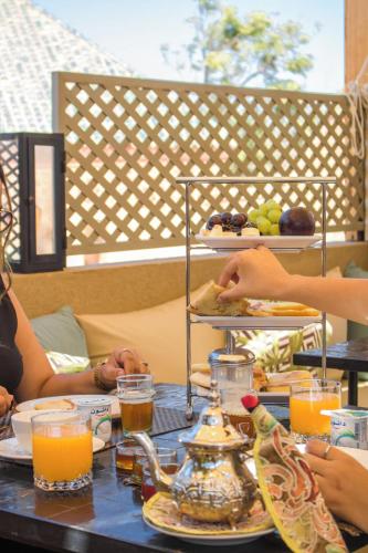 a group of people sitting at a table with food at Riad Al Rimal & Spa in Marrakech