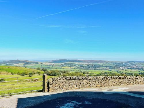 a stone wall and a pool with a view at Baxter Barn in Carleton