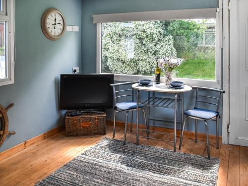 a small table and chairs in a room with a window at Seaglass Chalet - Uk47636 in Mundesley