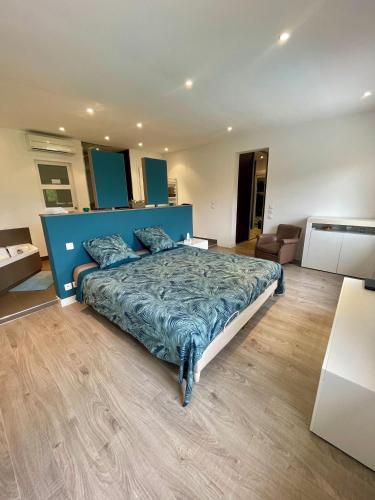 une chambre avec un grand lit avec une tête de lit bleue dans l'établissement VILLA Loakel, à La Gaude