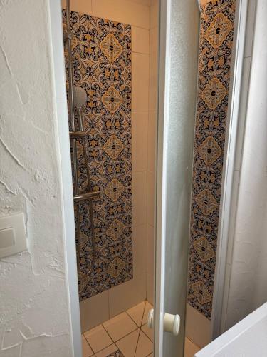 La salle de bains est pourvue d'une douche et d'un mur en carrelage. dans l'établissement L Estaquéenne, à Marseille