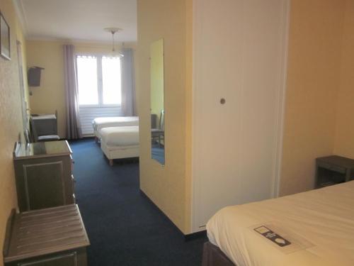 a hotel room with two beds and a window at Hotel La Chaumière in Saint-Jean-de-Monts