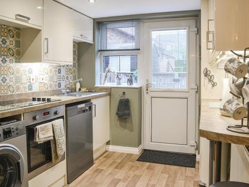 a kitchen with a washer and dryer next to a window at Middle Cottage in York