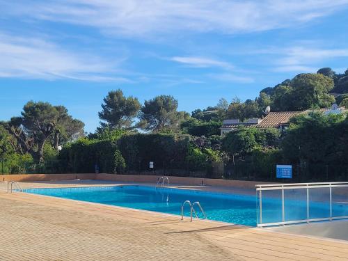 une piscine avec de l'eau bleue et des arbres en arrière-plan dans l'établissement Mas Flora, à La Croix-Valmer