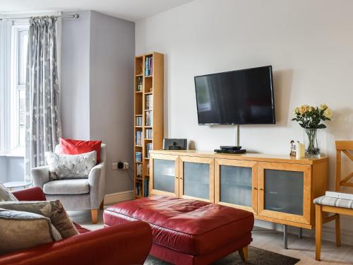a living room with a flat screen tv on a wooden entertainment center at Flat 3 Avon Villa in Bradford on Avon