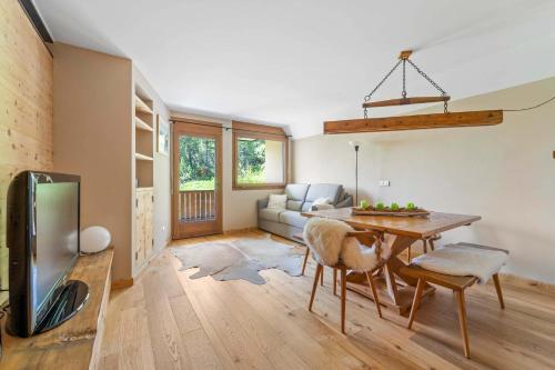 a living room with a table and a couch at Chic Wellness Apartment and Balcony in Maloja