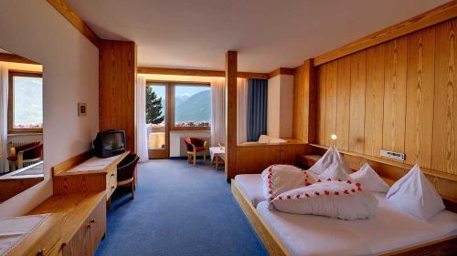 une chambre d'hôtel avec un lit et une télévision dans l'établissement Hotel Tirol, à Tirolo