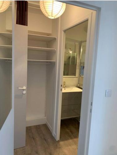 une salle de bain avec un lavabo et un miroir dans l'établissement Bel appartement avec piscine et proche plage, à La Rochelle