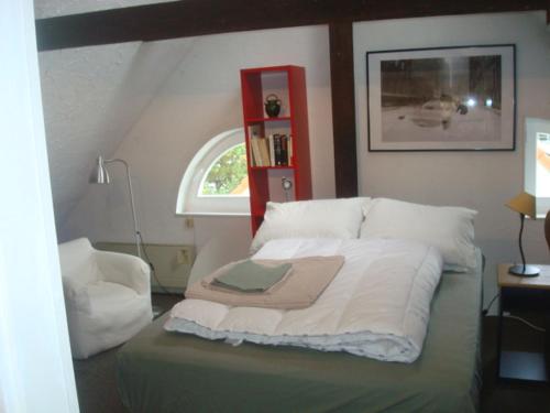 - une chambre avec un lit et un livre rouge dans l'établissement Cosy appartement quartier Orangerie, à Strasbourg