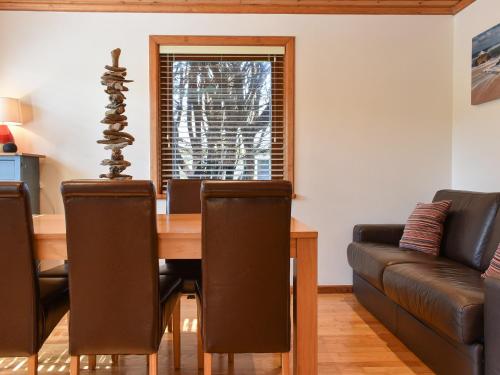 a dining room with a table and a couch at Madison in Jacobstow