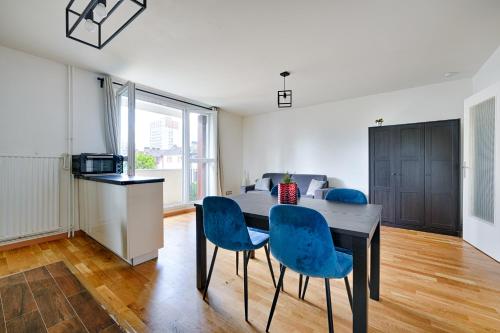 une salle à manger avec une table et des chaises bleues dans l'établissement Michelet, à Ivry-sur-Seine
