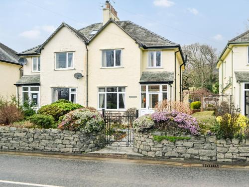 a white house with a stone wall at Parkfield in Keswick