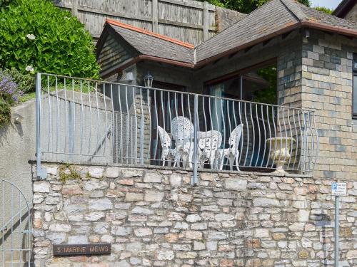 zwei Tische und Stühle auf einem Balkon eines Hauses in der Unterkunft Marine Mews 3 - Cottage in Salcombe