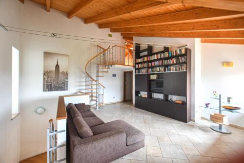 a living room with a couch and a book shelf at Casa Giorgina in Costa Vescovato