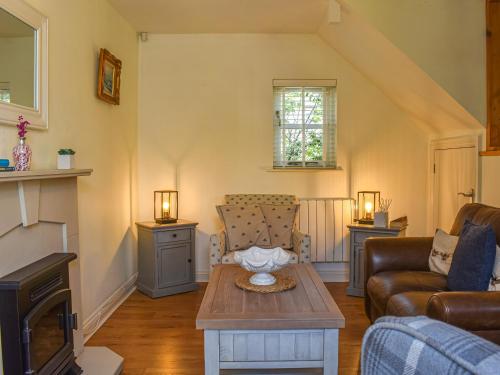 a living room with a couch and a table at Cosy Cottage in Holker