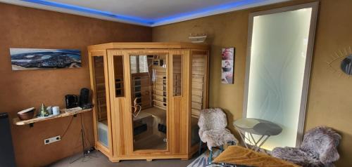 Cette chambre comprend une armoire en bois et 2 chaises. dans l'établissement Ty KamBreiz, à La Fresnais
