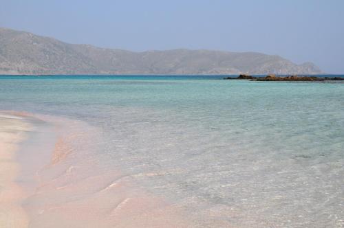 a beach with water and mountains in the background at Bikakis Family Apartments in Kissamos