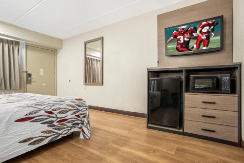 a bedroom with a bed and a flat screen tv at Red Roof Inn West Monroe in West Monroe