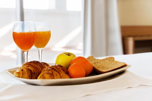 a plate of fruit and bread and two glasses of wine at Hotel Fontana Plaza in Torrevieja