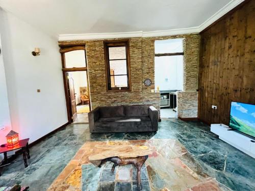 a living room with a couch and a tv at The Cave Suite in Obosomasi