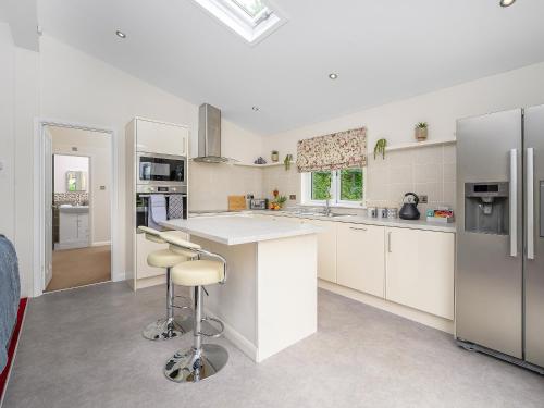 a kitchen with white cabinets and stainless steel appliances at Butterfly Lodge in East Farndon