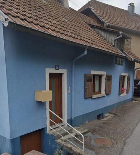 a blue house with a staircase in front of it at La maison bleue-Urbès in Urbès