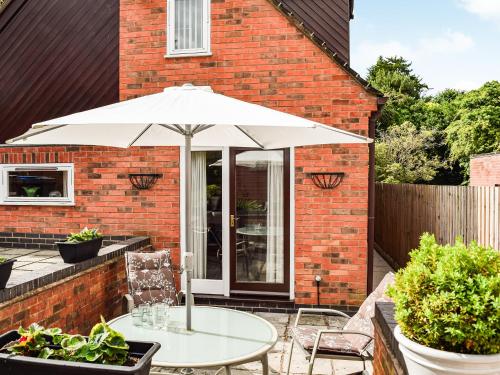 a white table with an umbrella on a patio at The Old Exchange in Market Bosworth