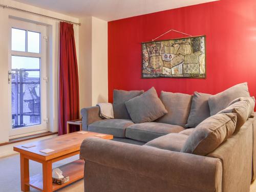 a living room with a couch and a red wall at The Retreat in Whitby
